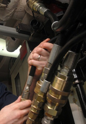 Hoses_and_fittings_from_US_Navy_081105-N-2456S-004_Aviation_Structural_Mechanic_Airman_Marty_Baum_connects_hydraulic_lines_to_the_hydraulic_drive_unit_(cropped)